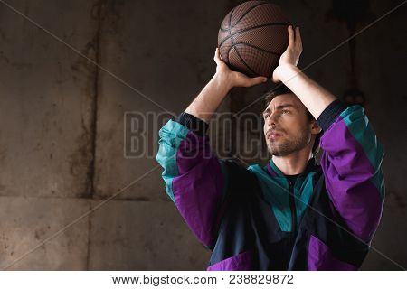 Handsome Young Man In Vintage Windcheater Throwing Basketball Ball