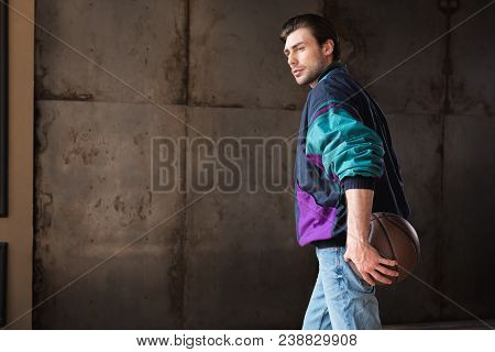 Serious Young Man In Vintage Windcheater With Basketball Ball