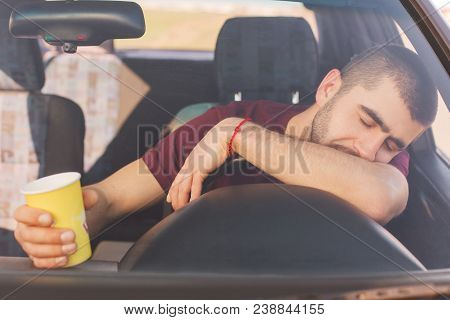 Fatigue Overworked Tired Male Driver Has Long Trip In Car, Makes Stop To Have Rest, Has Nap On Helm,
