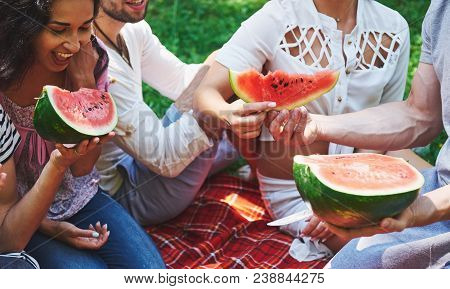 Cheerful Friends Enjoying Watermelon On Picnic On Sunny Summer Day.