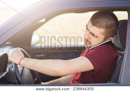 Male Driver With Concentrated Look Drives Car And Talks On Mobile Phone As Solves Important Problems