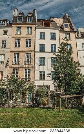 Sunny Blue Sky, Garden Greenery And Semidetached Buildings Typical Of The City Center Of Paris. Know