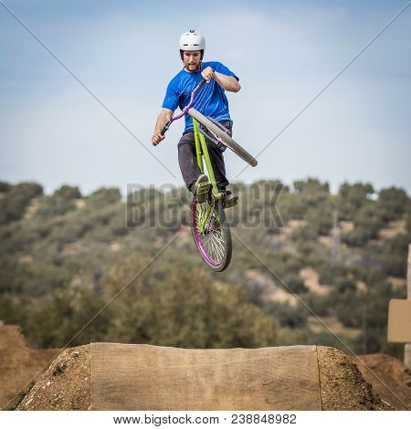Sportsman Performing Trick And Flying On A Bike In Nature On Dirtjump Circuit