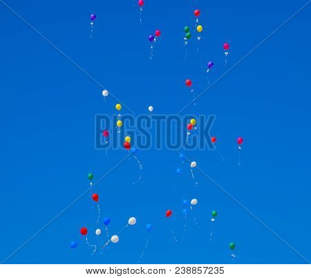 Multicolored Balls, Filled With Helium, Fly In The Blue Sky.
