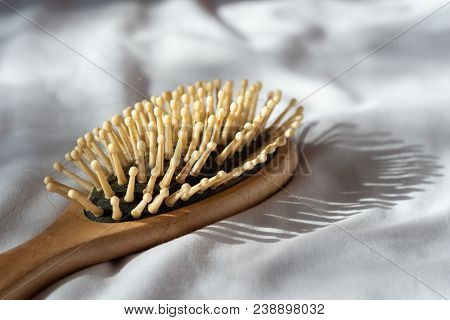 Hair Fall, Hair Loss Problem. Wooden Brown Comb With Hair Loss On White Bed Cover. Woman Healthy And