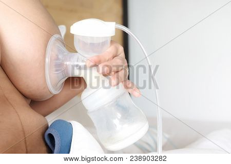 Happy And Young Asian Mother Is Pumping Breast Milk For Newborn Baby Feeding And Storage In Refriger