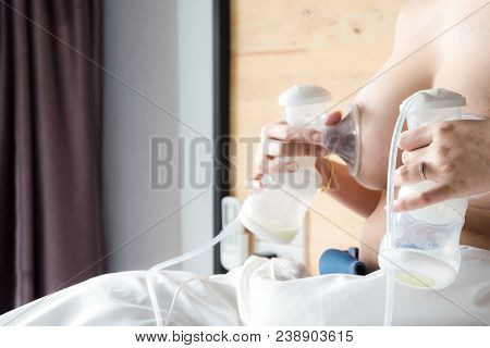 Happy And Young Asian Mother Is Pumping Breast Milk For Newborn Baby Feeding And Storage In Refriger