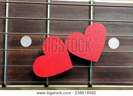 Red Hearts On The Strings Of A Guitar. Hearts Are A Symbol Of Love. Strings Of The Heart.