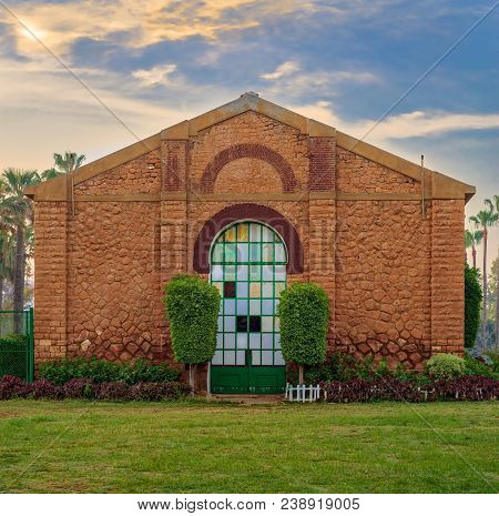 Side View Of The Royal Plant Nursery With Closed Grunge Door And Orange Painted Bricks Stone Wall De