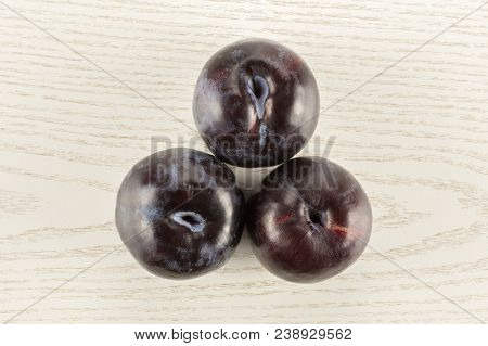 Three Red Blue Plums Table Top Isolated On Grey Wood Background Round Whole Fresh Juicy Fruit
