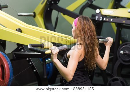 Sport, Fitness, Lifestyle And People Concept - Close Up Of Young Woman Flexing Muscles On Cable Gym 