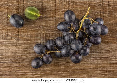 Black Grape Cluster (autumn Royal Variety) With One Sliced Berry Table Top Isolated On Brown Wood Ba