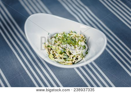 Top View Of A Salad In The White Plate On The Table With A Blue Tablecloth In White Strips. Salad Of