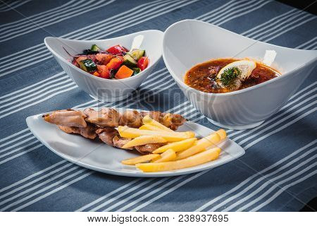 Set Of Three Dishes. Business Lunch Of Three Dishes. Three Dishes On White Plates On A Table With A 