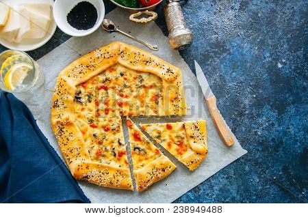 Arabic And Middle Eastern Food Concept. Cheese And Labneh Savory Galette With Olives On A Baking Pap