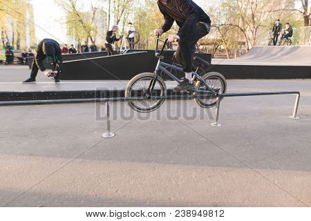 Bmx Bike Racing In A Park Skate. Bmx Rider Makes A Trick On The Handrail. The Videographer Removes A