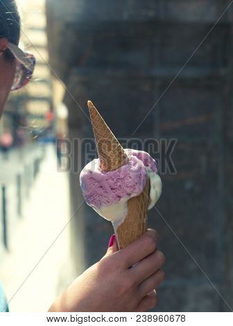 A Woman Holding Pink Colored Ice Cream. Summer Time In The Street Of The Old City