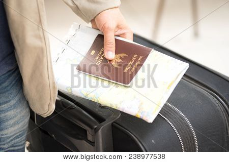 Business Suit In A Passport With A Suitcase.