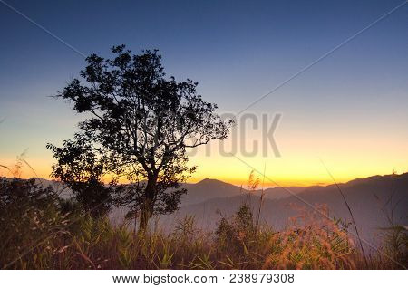 Beautiful Dramatic Sunset In The Mountains. Landscape With Sun Light Shining Through Orange Clouds