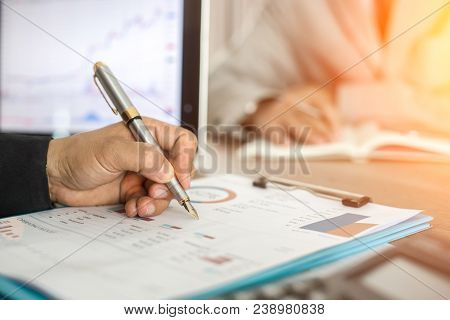 Two Business People Calculate Their Business In The Office.