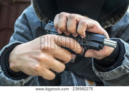 A Man Holding A Gun On His Back. The Gunman Held His Gun Behind Him.crime Concept.criminality Concep