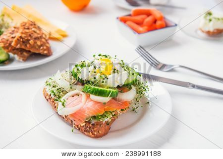 Cereal Bun With Egg Benedict, Smoked Salmon, Sprout Micro Greens, Onion And Cucumber Slices, Cream C