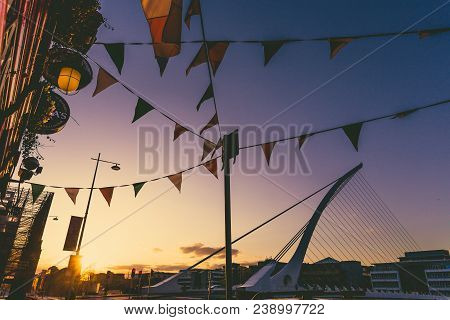View Of Dublin's Famous Samuel Beckett Bridge Over The River Liffey At Sunset