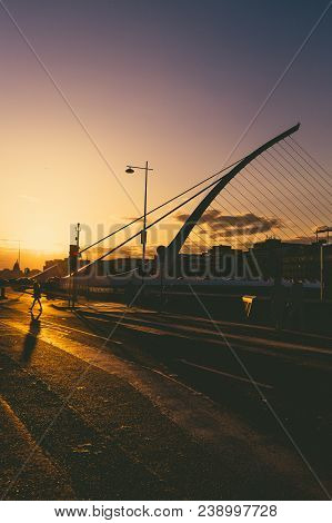 View Of Dublin's Famous Samuel Beckett Bridge Over The River Liffey At Sunset