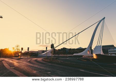 View Of Dublin's Famous Samuel Beckett Bridge Over The River Liffey At Sunset