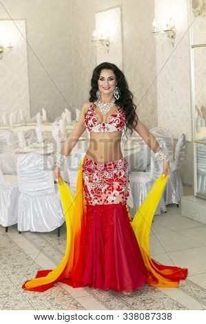 Belly Dancer Throws The Ends Of Her Beautiful Orange Skirt Into Air Oriental Dancer In A Red-yellow 