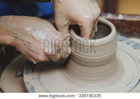 Woman Hands On Pottery Wheel, Potter At Work. Craftsman Artist Shapes Pot