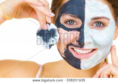 Woman With Clay Carbo Black Mask On One Half Face And White Mud On Second Half. Girl Removing Cosmet