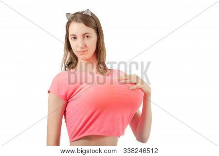 Young Woman Shows Her Big Fake Breasts Isolated On White Background Looking At Camera Smiling