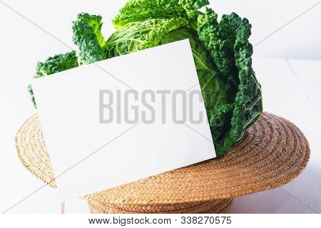Grenery Mock Up Invitation Card Or Baby Card With Fresh Savoy Cabbage In A Straw Hat On White Wooden
