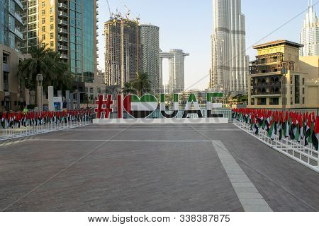 Dubai / Uae - December 3, 2019: Many Uae National Flags With Dubai Skyscrapers And Burj Khalifa On B