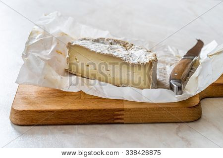 Half Cut Whole Brie Cheese With Knife On Wooden Board Also Called Turkish Mera From Goat Milk.