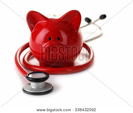 Close-up Of Red Piggy-bank To Save Up Money And Clinical Equipment Stethoscope. Budget For Health Ch