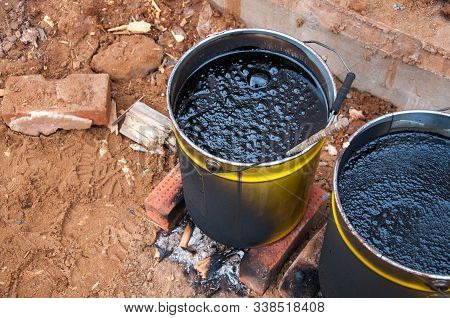 Bitumaning The Mastics In Yellow Jars. Material For Waterproofing The Foundation. The Mastika In The
