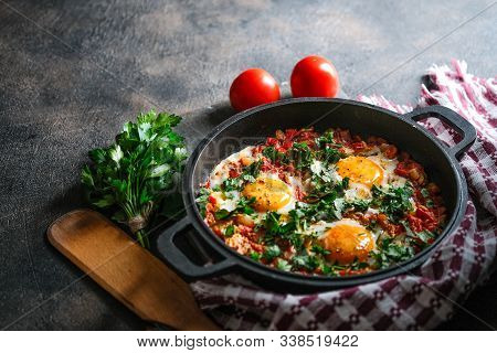 Shakshuka With Eggs, Tomato, And Parsley In A Iron Pan. Top View Copy Space