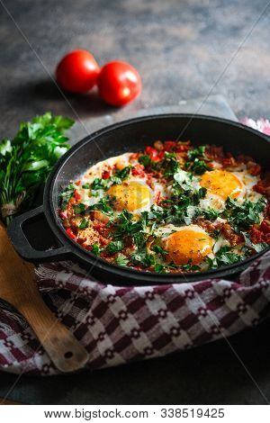 Shakshuka With Eggs, Tomato, And Parsley In A Iron Pan. Top View Copy Space