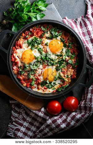Shakshuka With Eggs, Tomato, And Parsley In A Iron Pan. Top View Copy Space