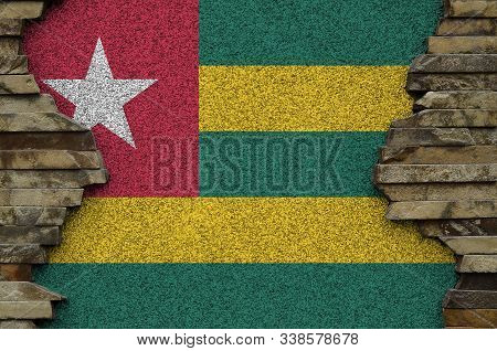 Togo Flag Depicted In Paint Colors On Old Stone Wall Closeup. Textured Banner On Rock Wall Backgroun