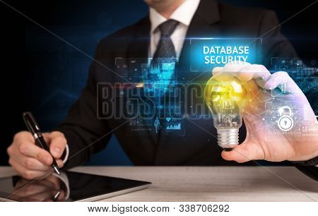 Businessman holding lightbulb with DATABASE SECURITY inscription, online security idea concept