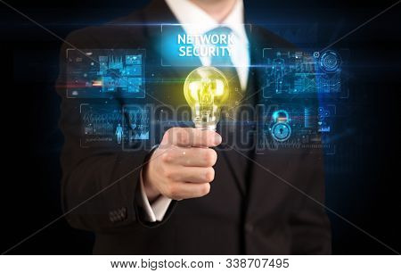 Businessman holding lightbulb with NETWORK SECURITY inscription, online security idea concept