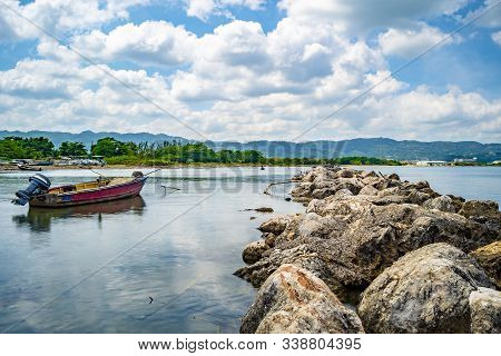 Empty Old Wooden Fishing Motor Boat Docked Near Shore. Scenic Ocean Water View Setting From The Nort