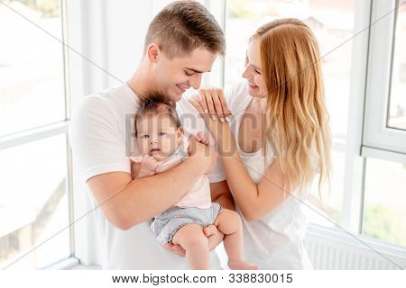 Young couple with beautiful baby at home