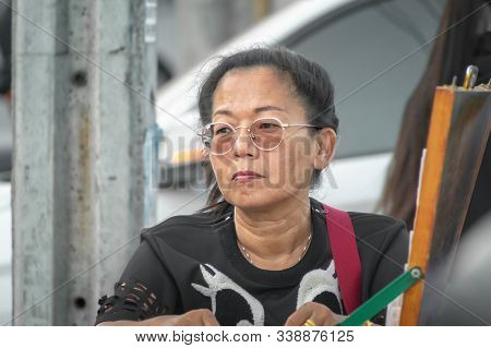 Bangkok, Thailand - December 08: Unnamed Middle Aged Woman Stares At The Street On Petchkasem 60 As 