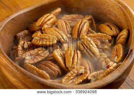 Pecan Nuts In A Wooden Dish On A Wooden Table