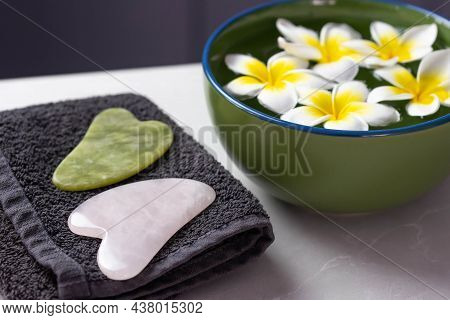 Beautiful Spa Composition With Plumeria Flowers. Face Roller And Guasha Massager. Facial Skin Care, 