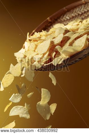 Falling Potato Chips On A Yellow Background. Copy Space.